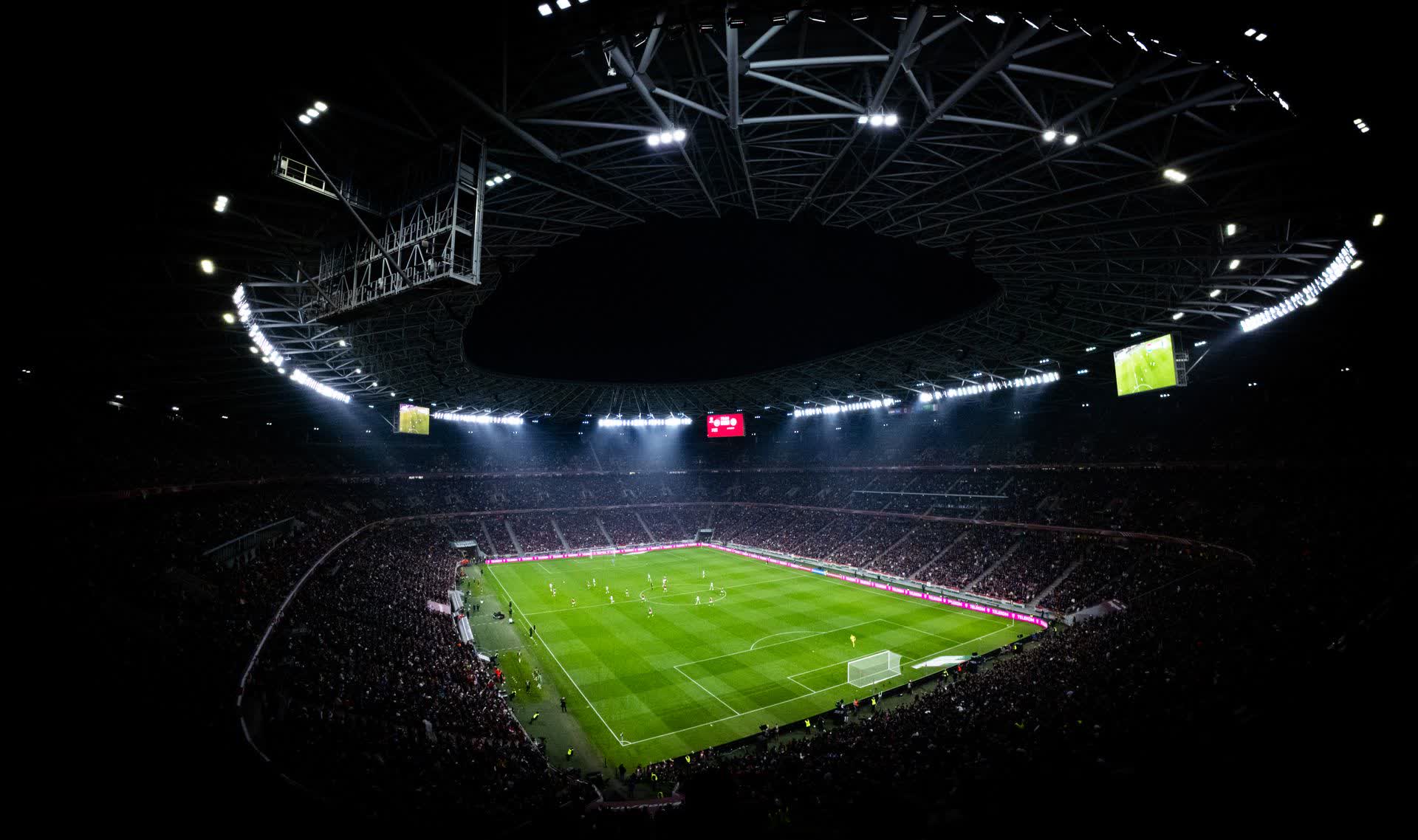 Packed football stadium lit up at night